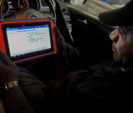 Technician working on an opened manual gearbox at the workshop bench