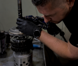 Technician lowering the shaft and planet carrier into an automatic transmission clutch drum